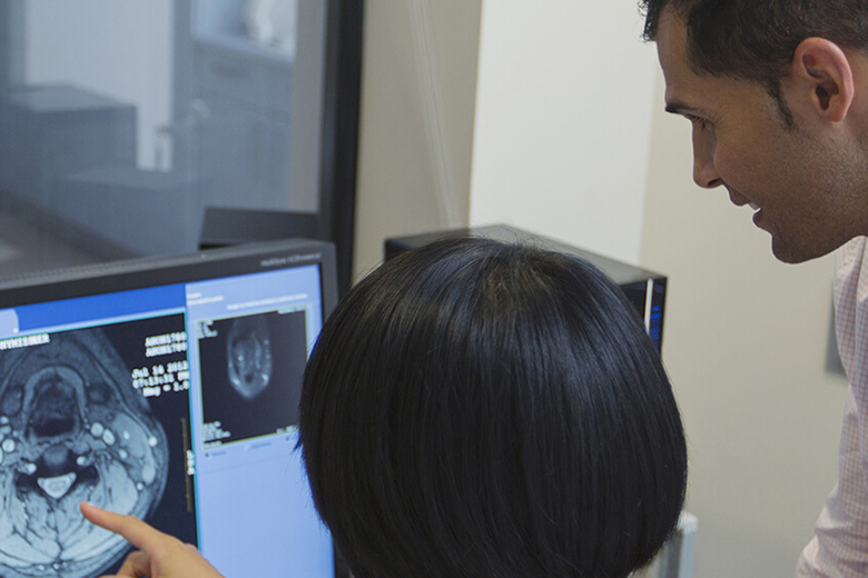 Neurologists look at brain scan on computer